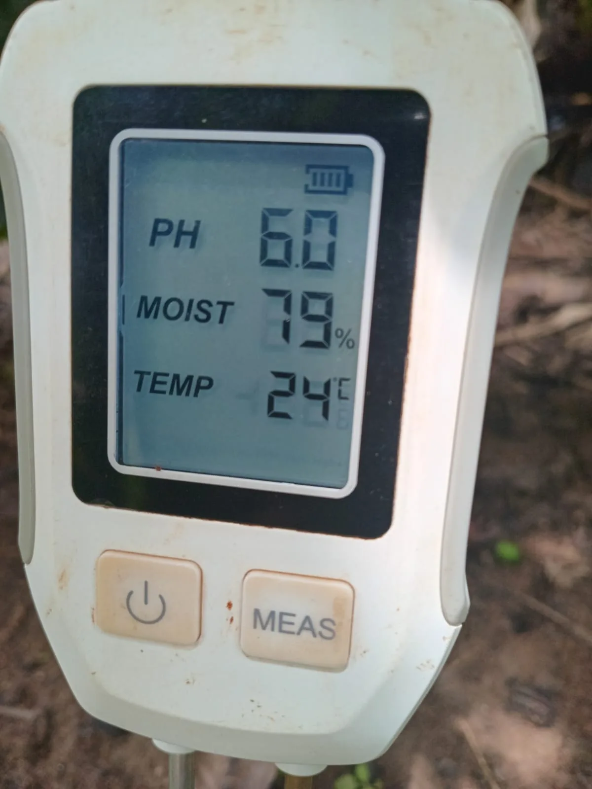 Soil meter display showing pH, moisture and temperature